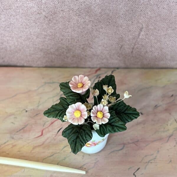 Rosa miniature blomst med tørrede blomster og grønne blade