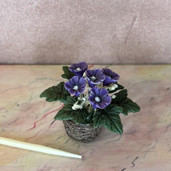 Violette blomster i flettet potte