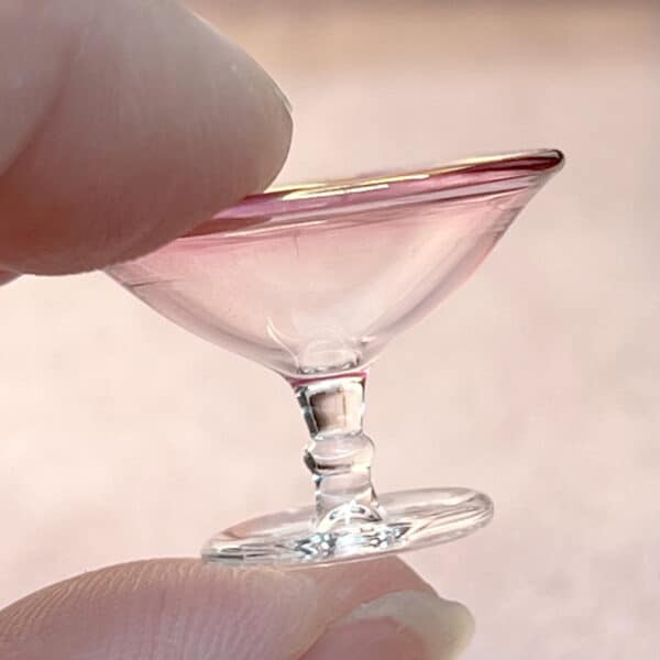 Glas skål i miniature som skifter fra tranebærglas til klart glas.