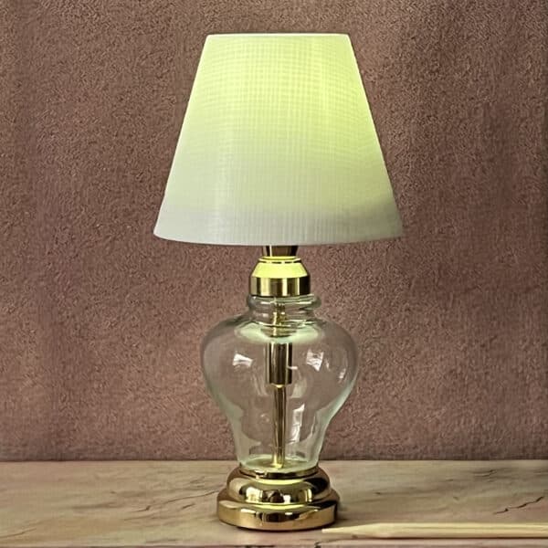 Bordlampe i messing, med glasfod og plast lampeskærm. Lampeskærmen kan monteres med stof eller papir med de ønskede farver og designs.
