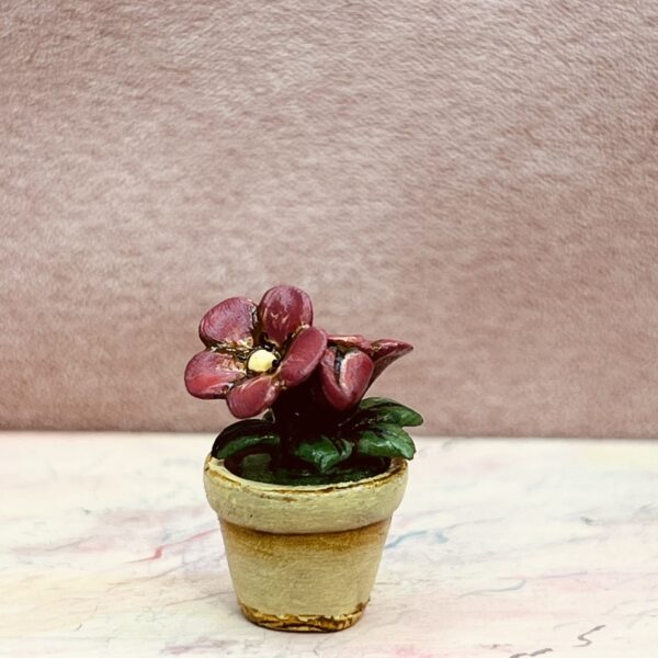 Miniature blomster i lysgul potte