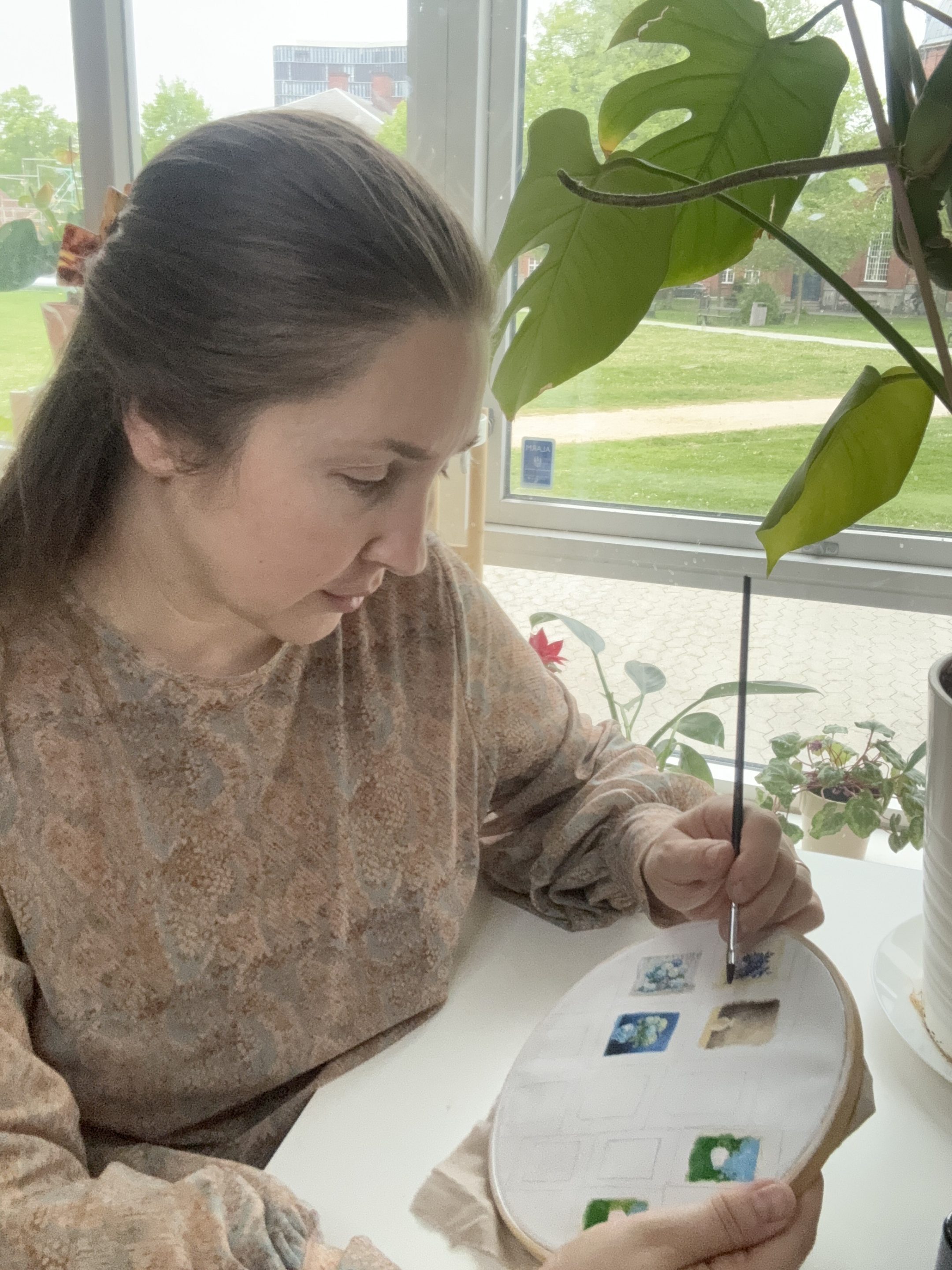 Alona fra Ukraine igang med at male små kunstværker til dukkehuset